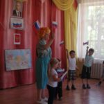 В заключение праздника Карлсон вместе с детьми проходят по зхалу с Российским флажком