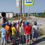 дети с воспитателем (Никитина В.П.) закреляют знаки дорожного движения